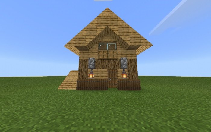 Небольшой деревянный домик, крыша которого сделана из блоков с уклоном