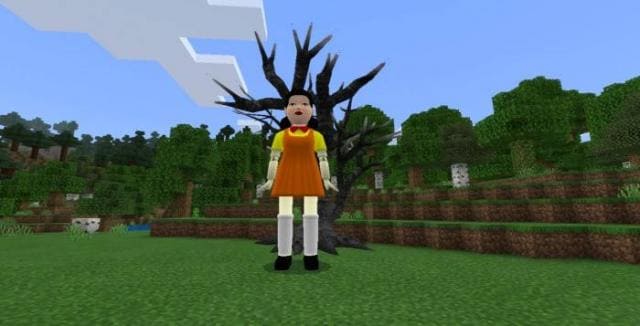 Огромная кукла и дерево позади